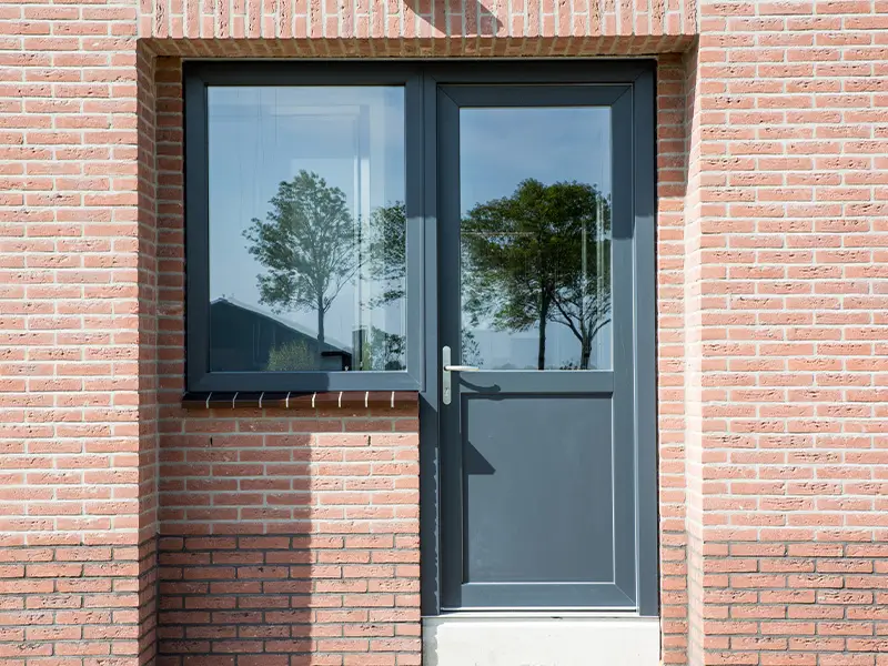 Grijze kunststof deur met raamkozijn