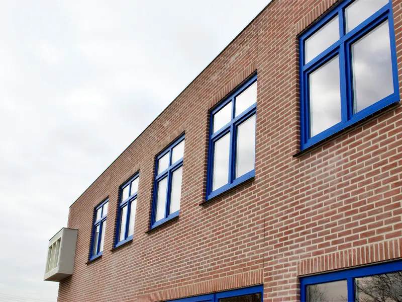 Blauwe kunststof draai-kiepkozijnen in bedrijfsgebouw